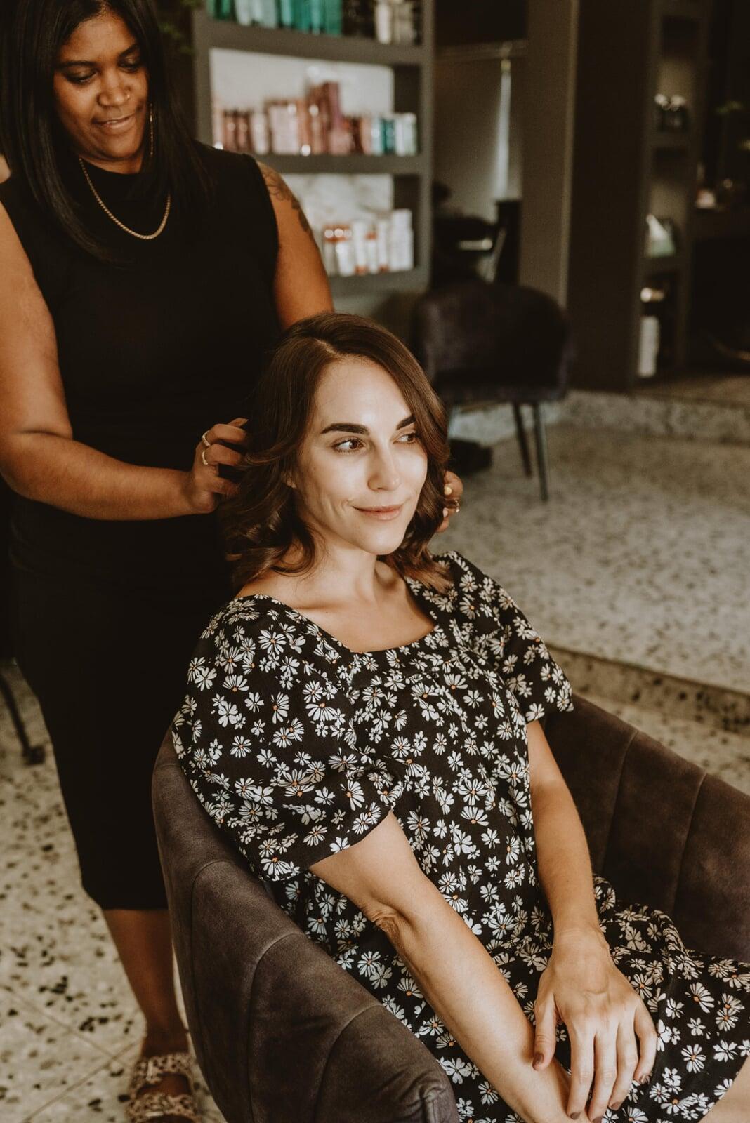 A client smiling and getting her hair cut.